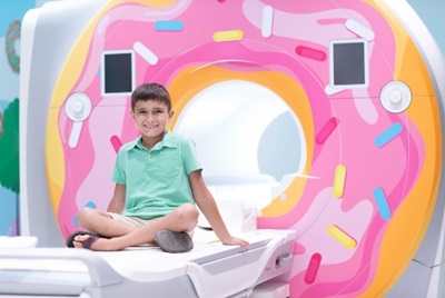 Young boy sitting on an Pediatric MRI machine